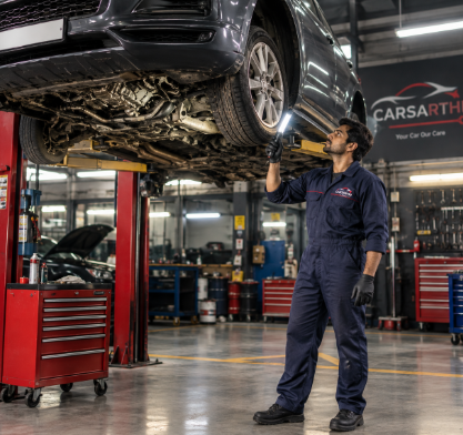 Car raised on a hydraulic lift while a technician inspects the suspension during service