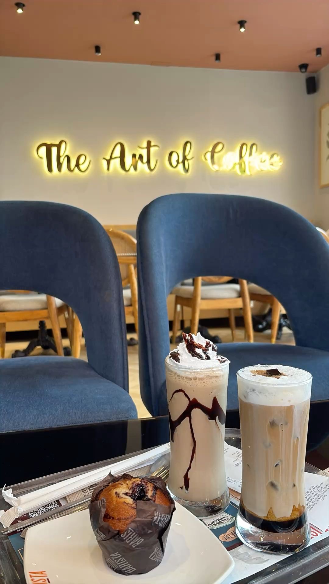 Two lattes with sandwiches at white table