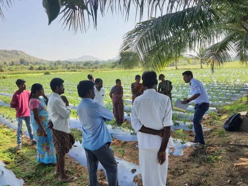 Trainer guiding farmers in a polyhouse workshop - best farmer training programs in Karnataka
