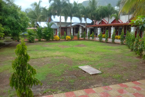 Madhuson Palms family homestay exterior with lush greenery and traditional architecture in Karjat